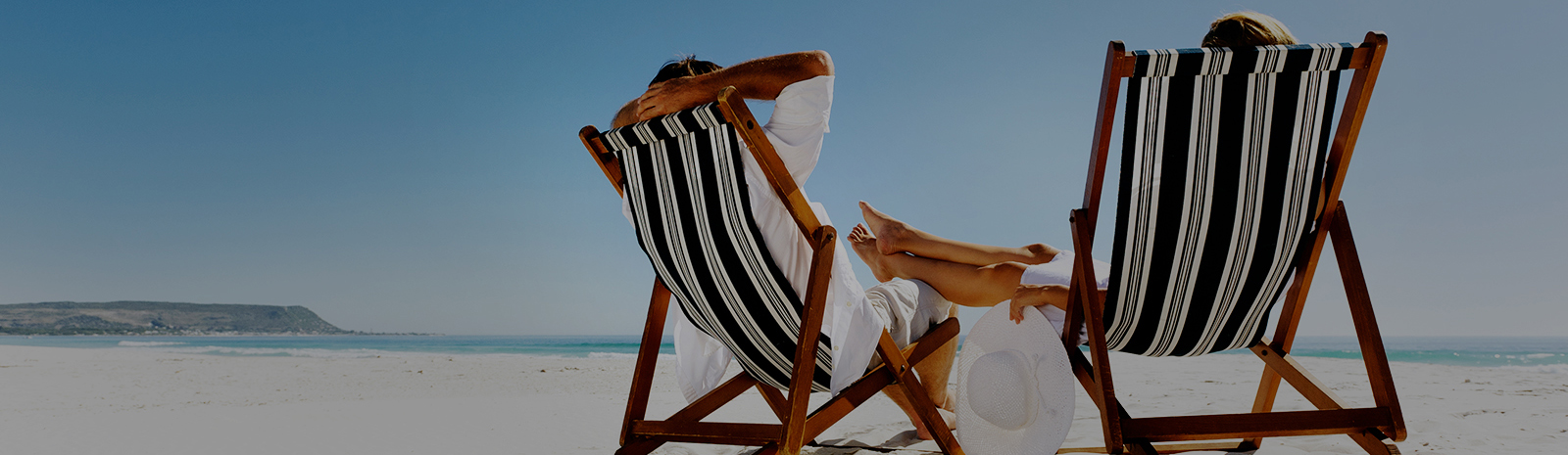 couple sitting on beach chairs relaxing by the beach