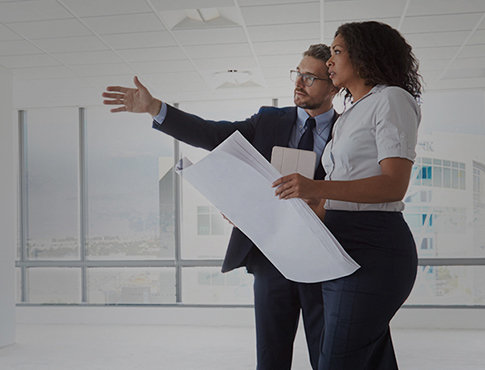 man and woman looking at building plans and building space